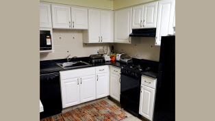 kitchen with granite counters, black appliances and white cabinets