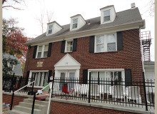 red brick house with a porch and black shutters