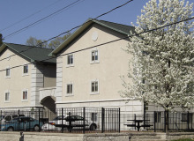 two tan apartment buildings with parking lots