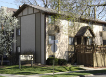 tan apartment building with trees blooming