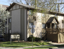 tan apartment building with trees blooming